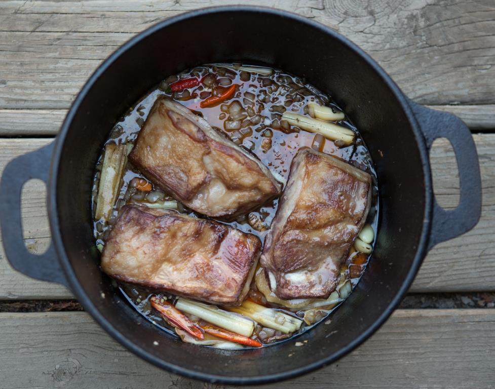 Lamb Riblets slow cooking in fish sauce with onions and lemongrass. 