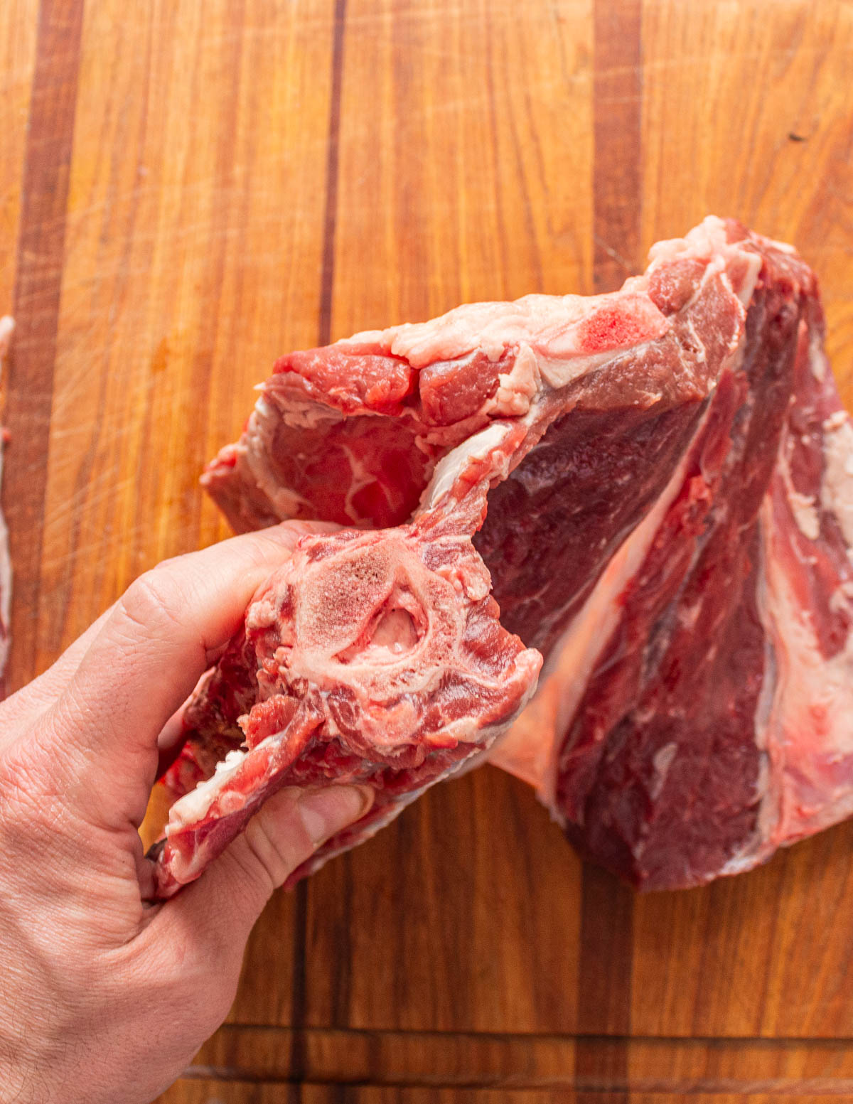 Removing the spine from a lamb saddle using a paring knife.