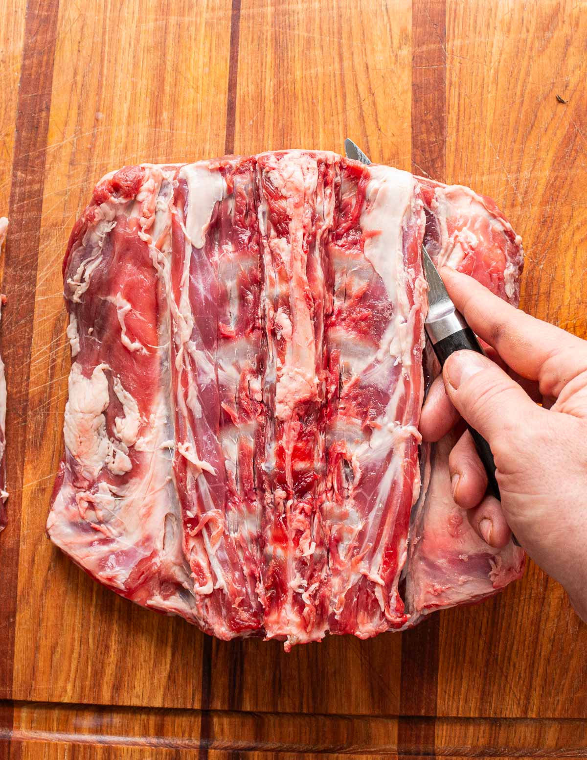 Making a cut to remove the spine from a lamb saddle.