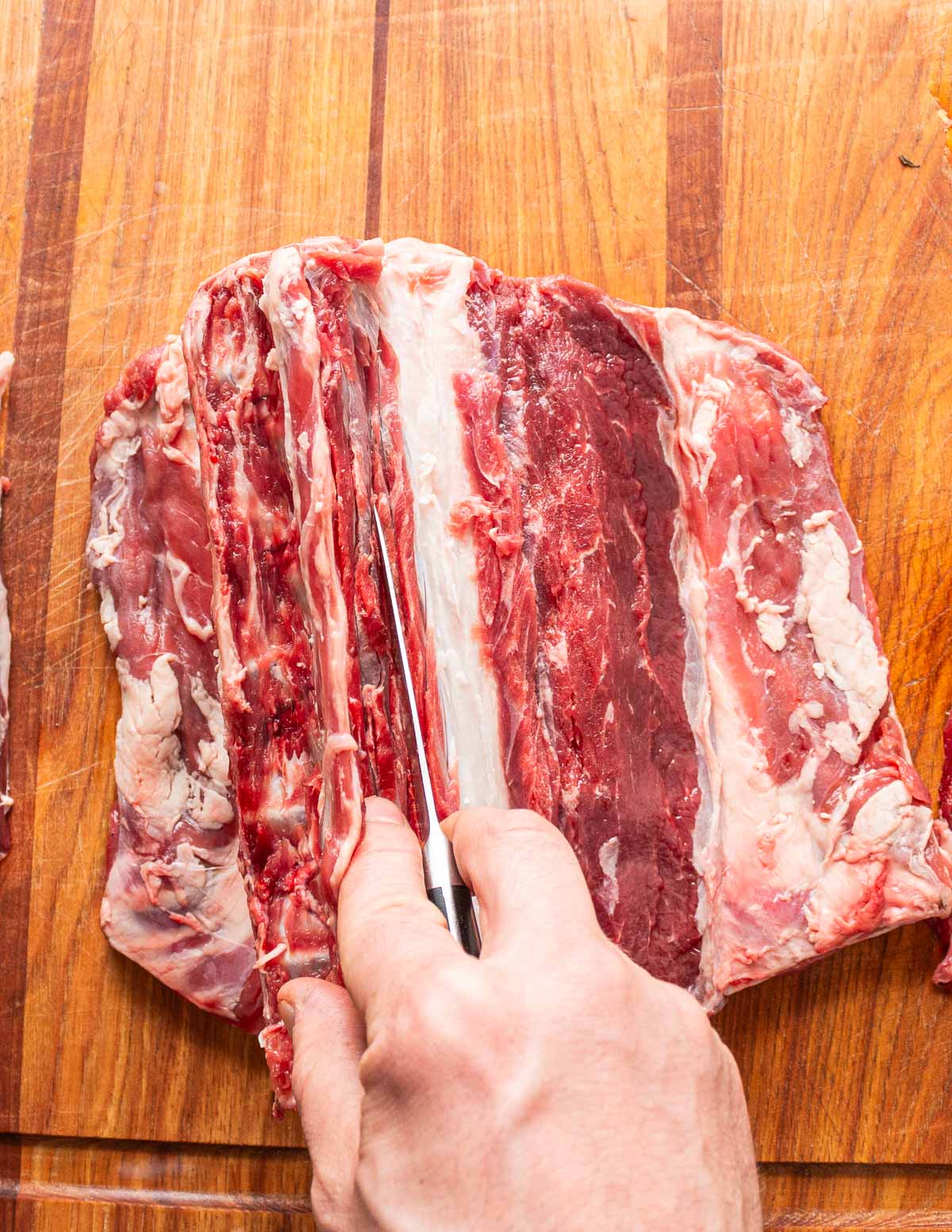 Removing the spine from a lamb saddle.