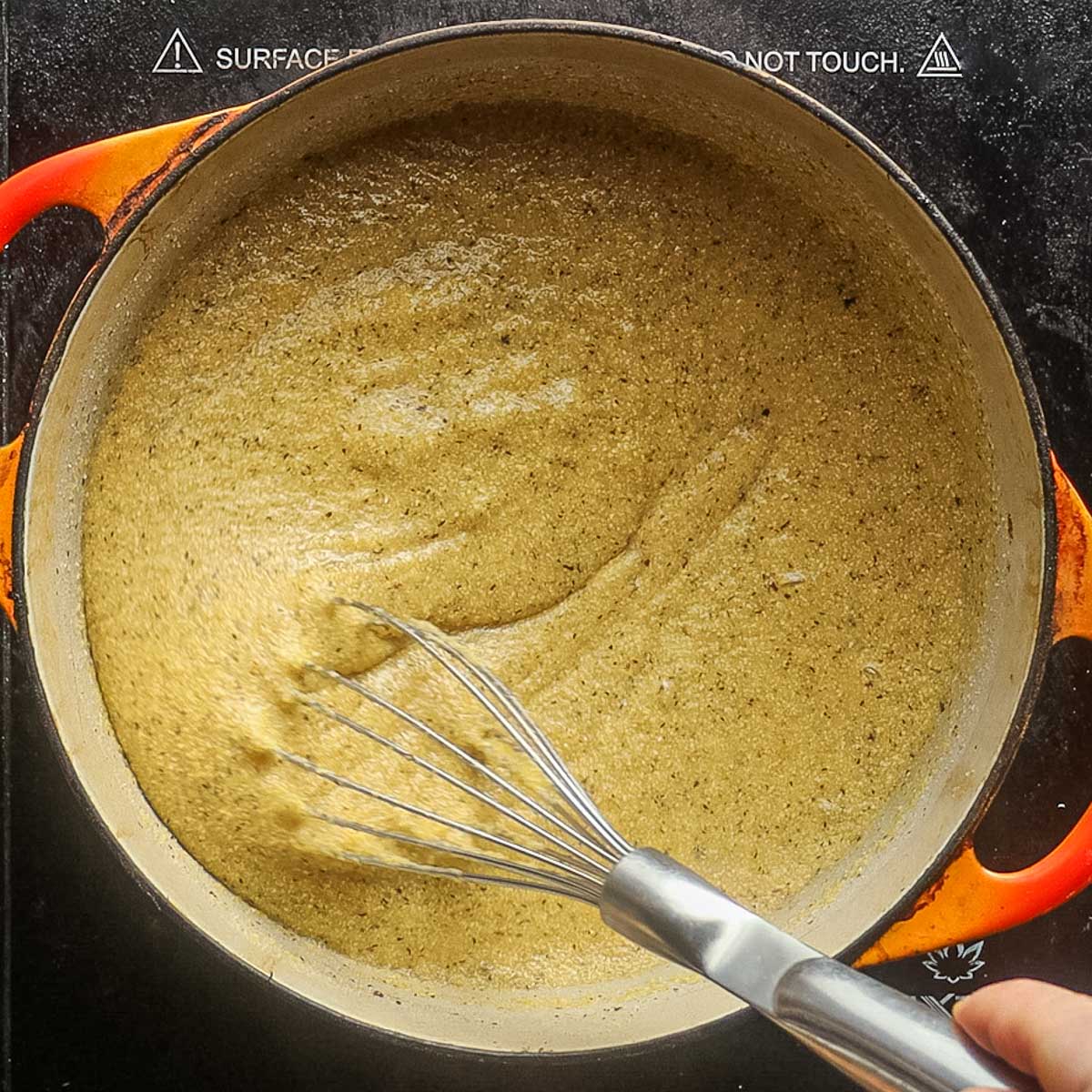 Whisking cornmeal until thickened.