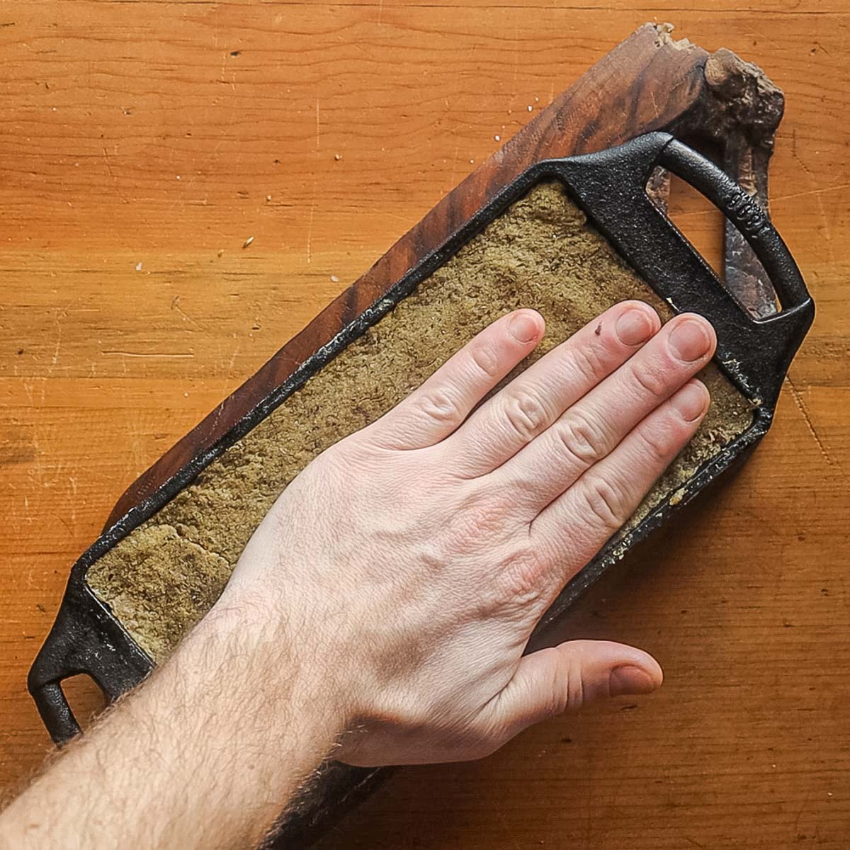 Pressing scrapple down to remove air pockets.