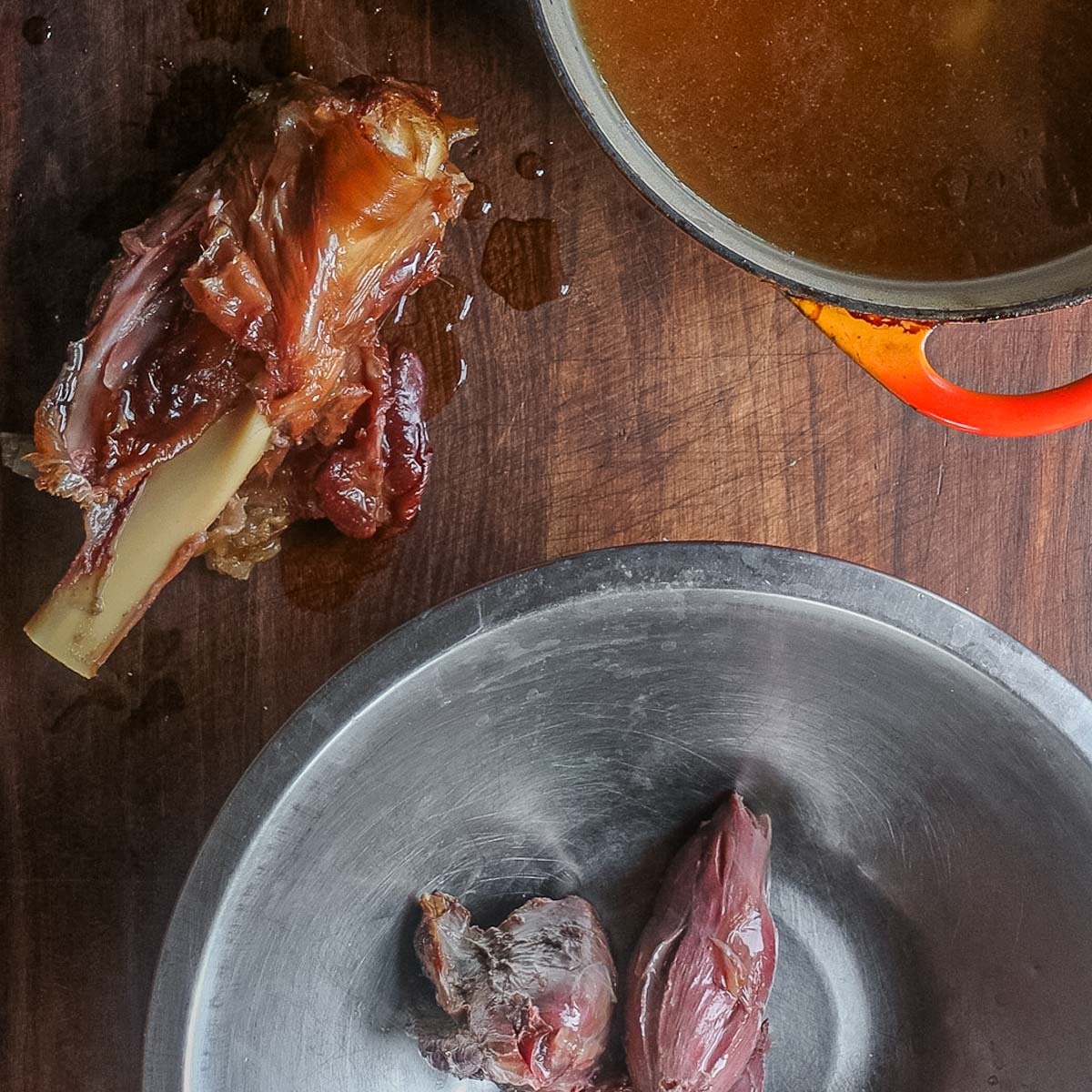 Removing meat from a smoked lamb shank.
