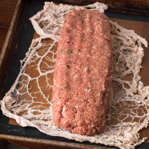 Wrapping lamb and goat bacon meatloaf in caul fat