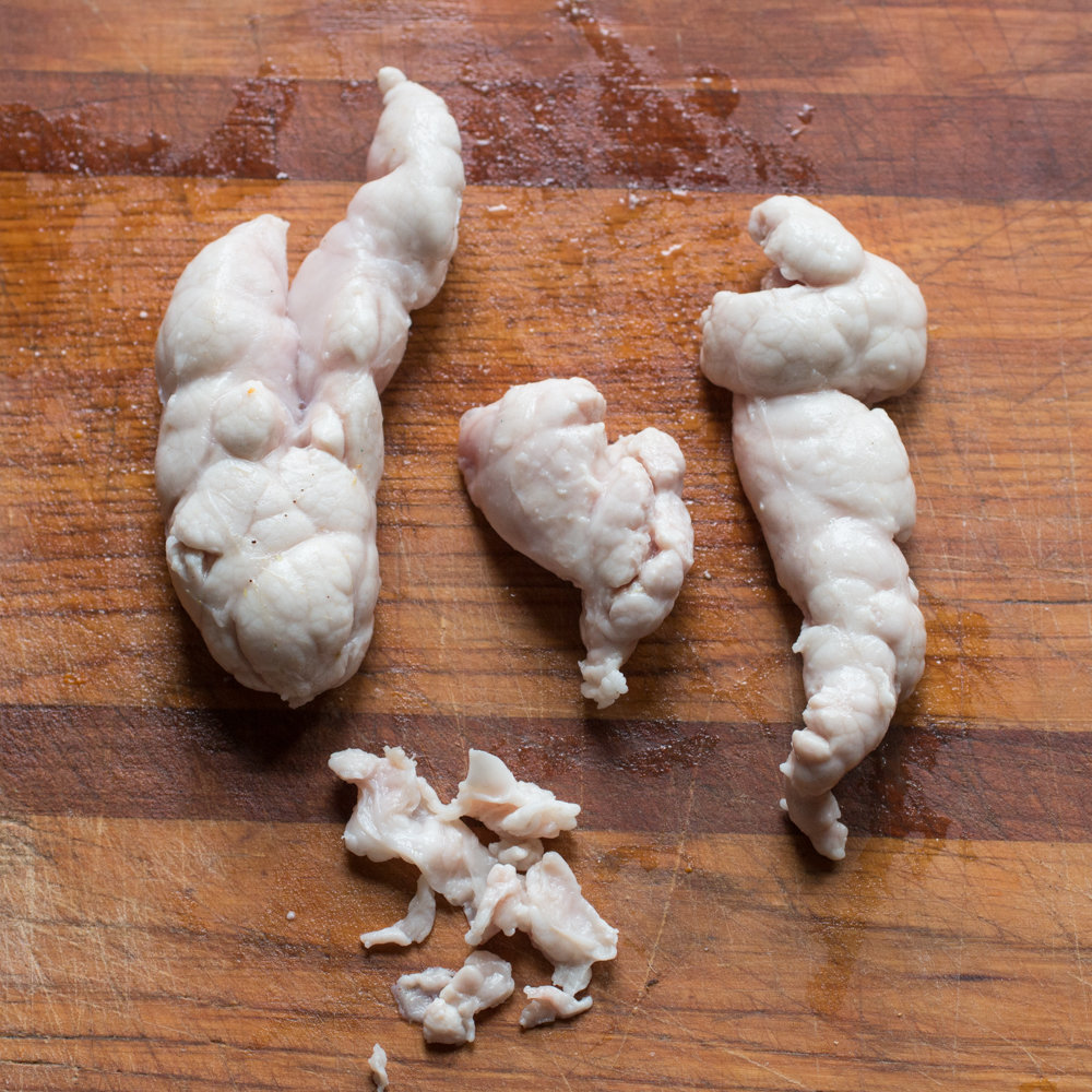 Removing the connective tissue from lamb sweetbreads.