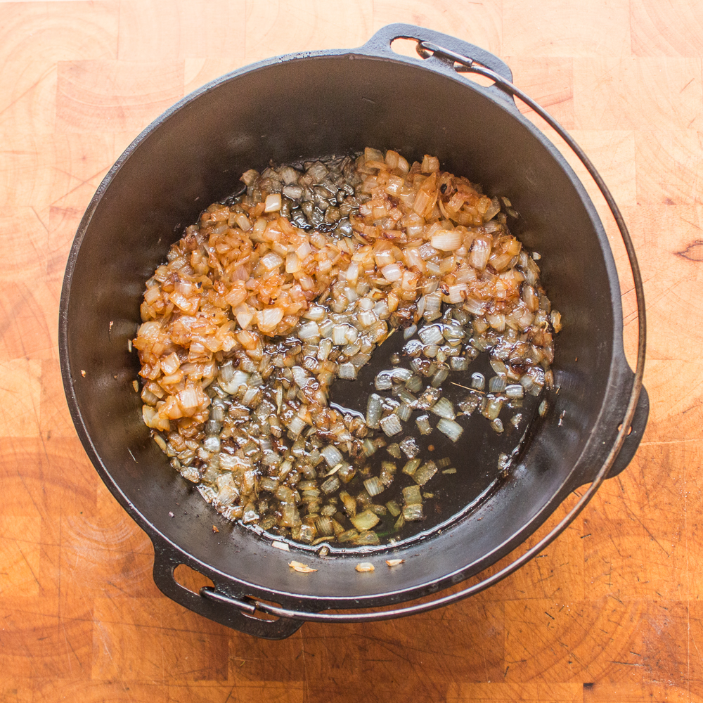 Cooking onions in a Dutch oven to make plov.