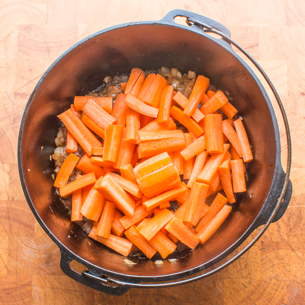 Cooking carrots in a Dutch oven to make plov.