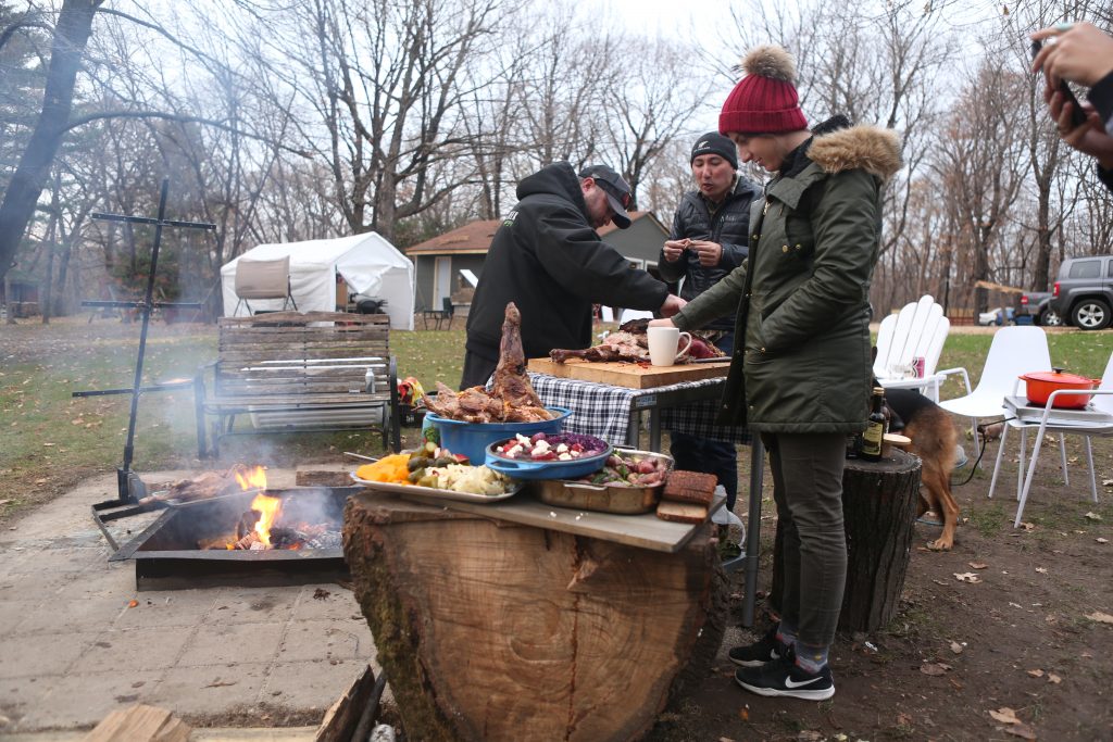 People enjoying eating a whole lamb cooked asador.