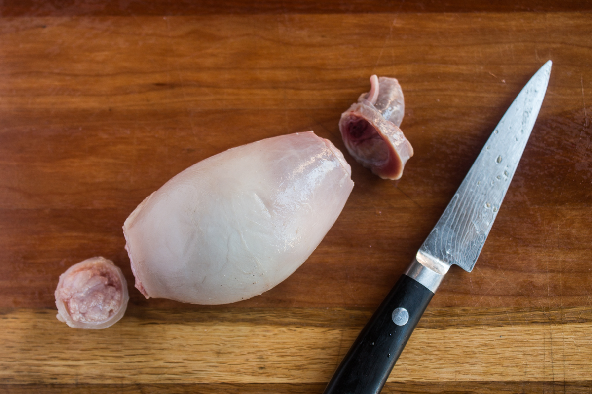 Slicing the ends from lamb fries to remove the outer sheath.