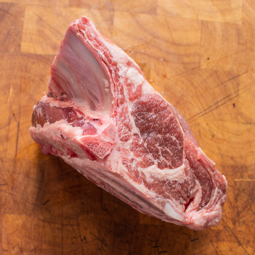 Saratoga lamb roast or saratoga roll seen from the rib side on a cutting board.