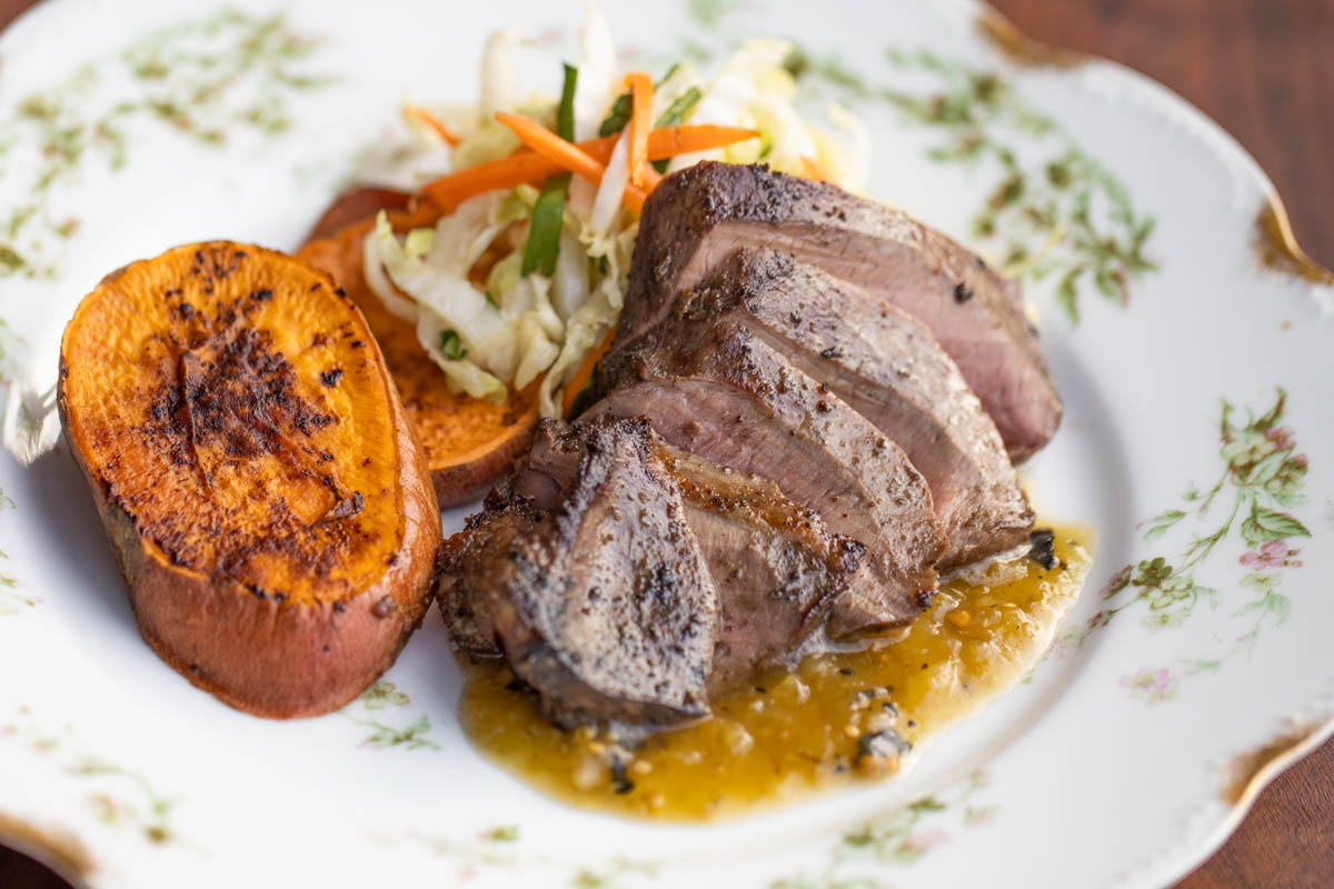 sliced grilled lamb heart with salsa verde sweet potatoes and cabbage slaw 