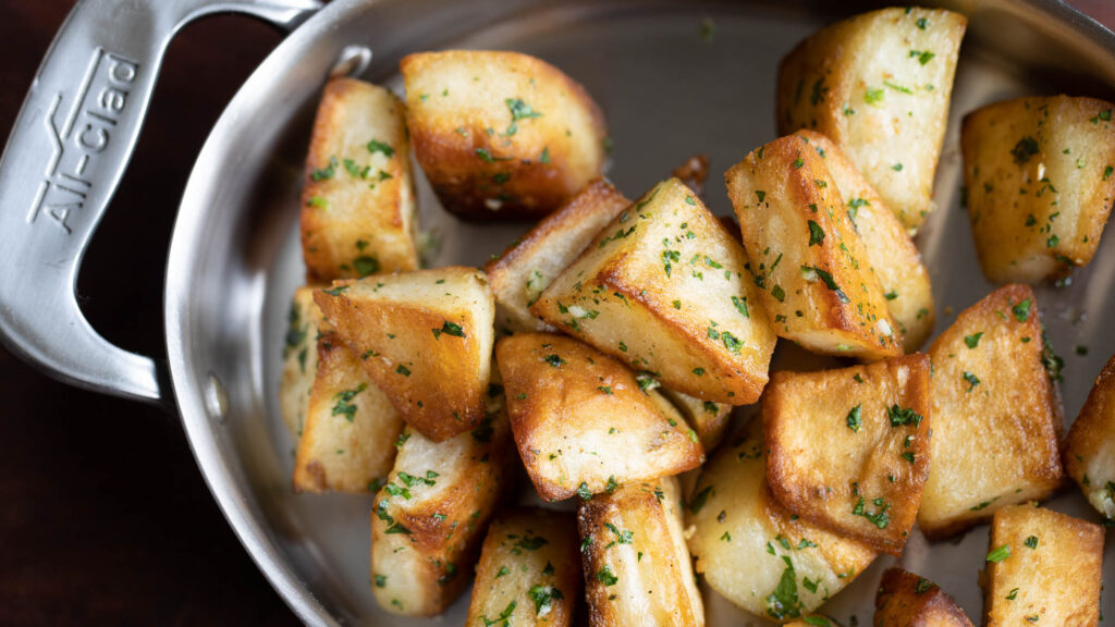 Crispy lamb fat potatoes in an all clad dish.