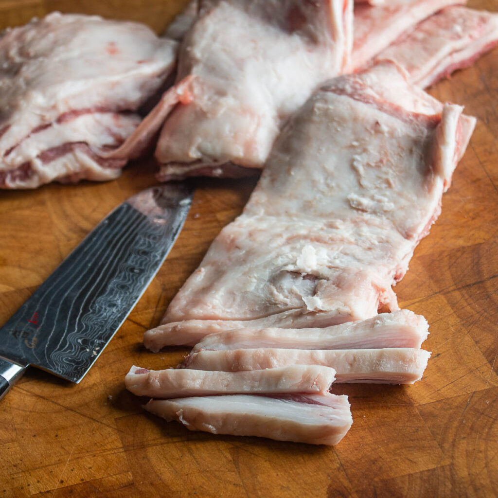 Cutting lamb fat caps for chicharrones de borrego