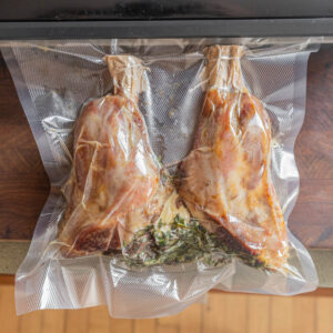 Vacuum sealing lamb shanks with thyme, butter and garlic.