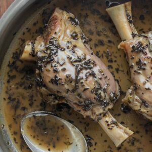 A top-down picture of slow cooked lamb shanks in a mushroom sauce.