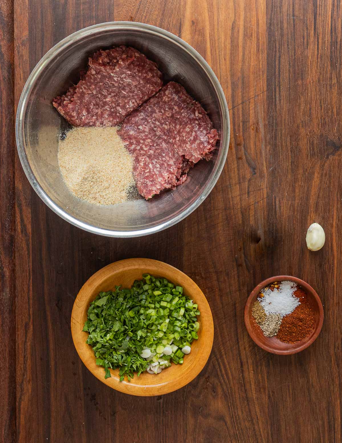 Mixing ground lamb with breadcrumbs and spices to make meatballs.