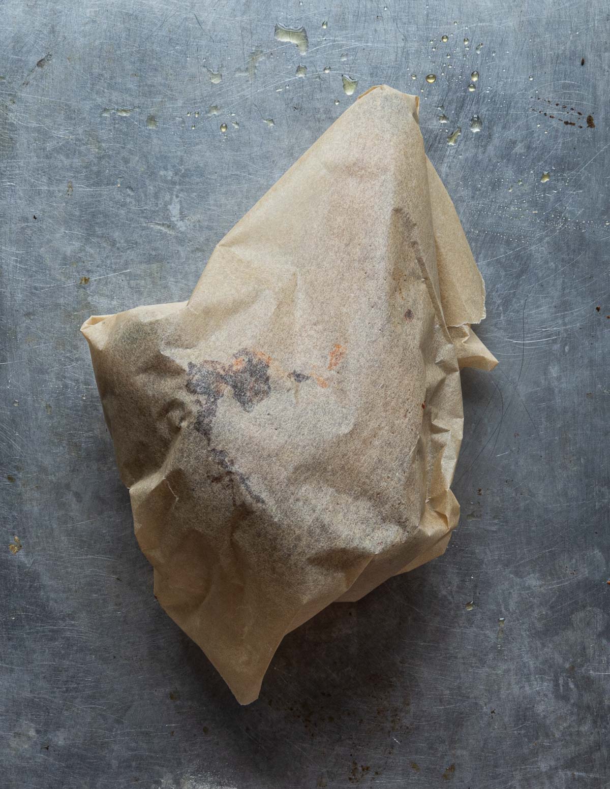 A smoked lamb shank wrapped in parchment paper.