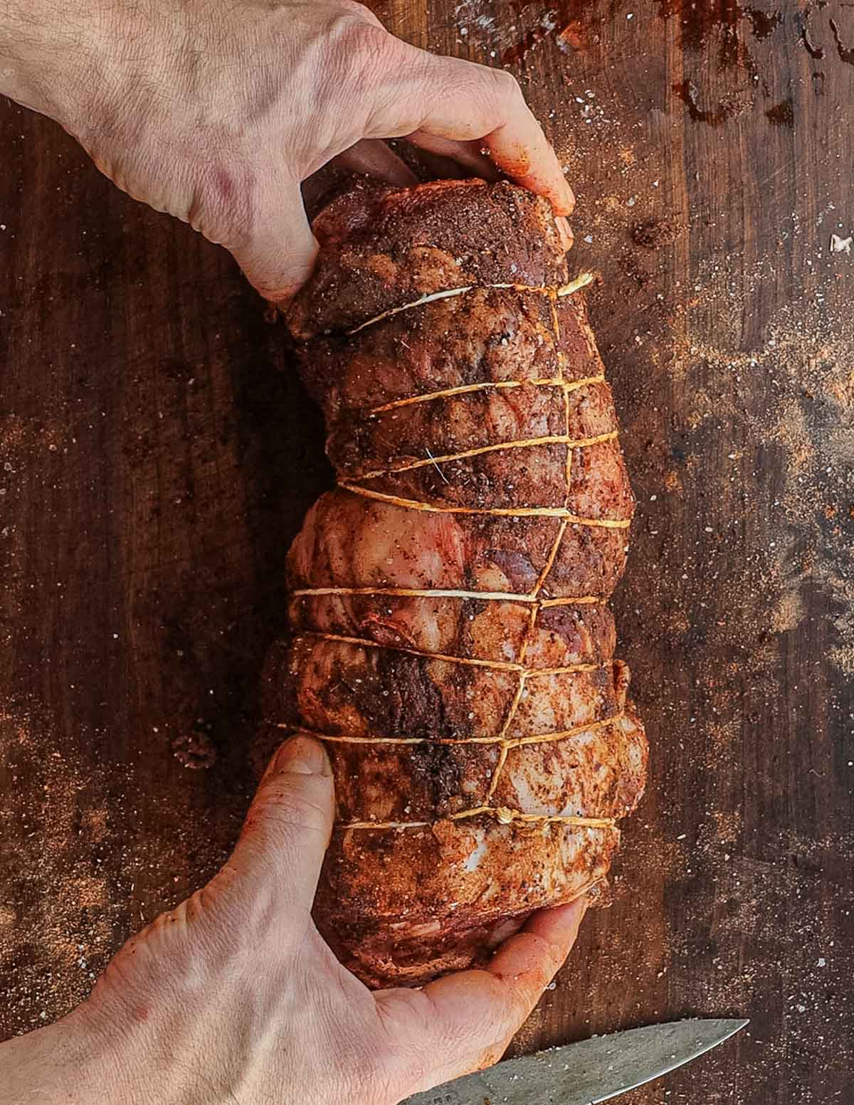 A fully tied, seasoned boneless leg of lamb in butchers twine.