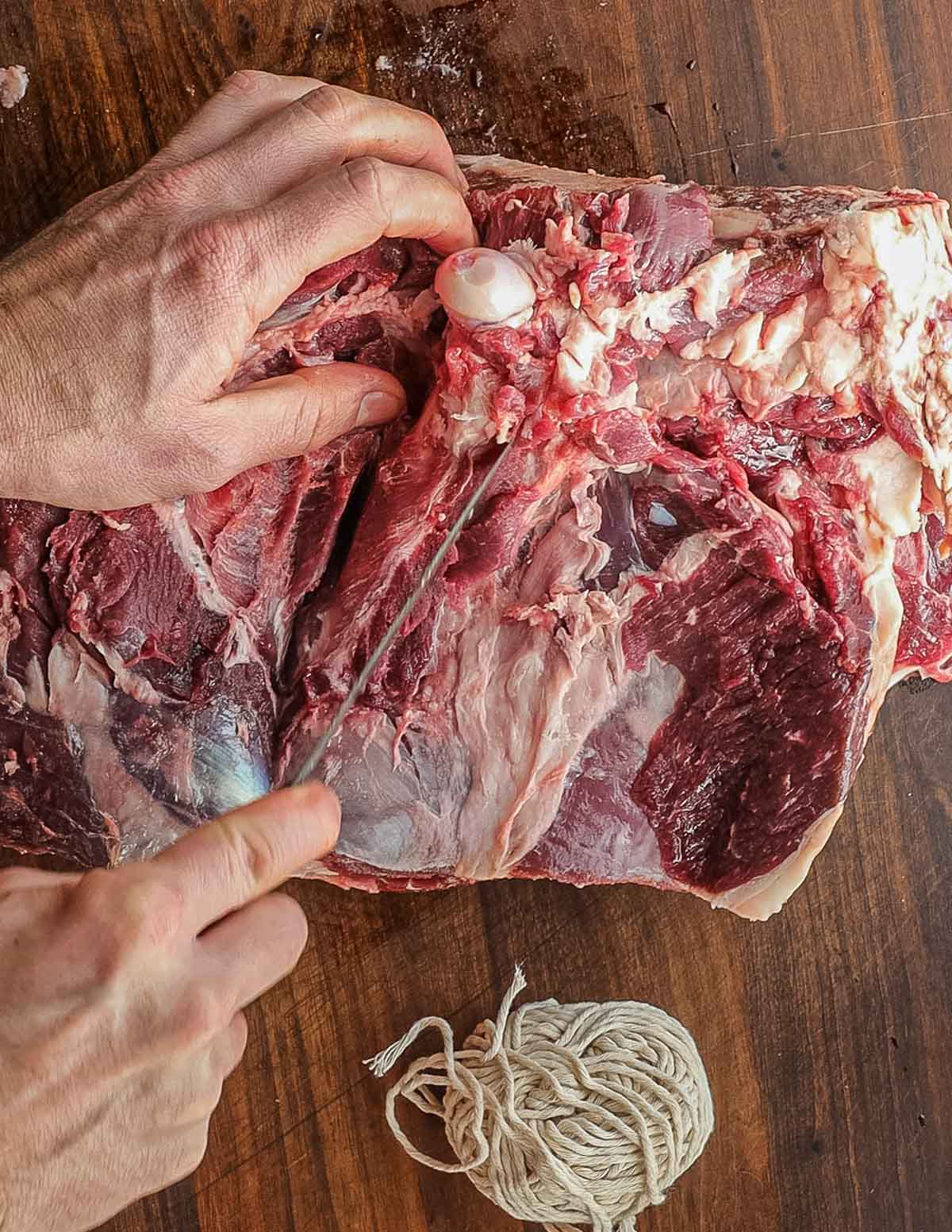 Removing the leg bones from a leg of lamb.
