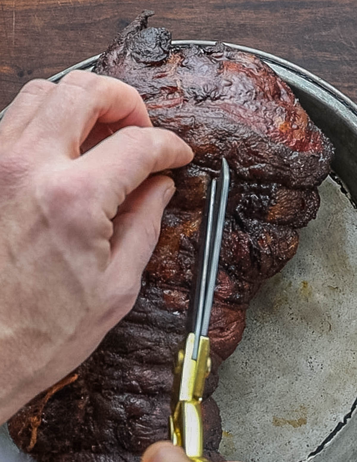 Cutting the twine off of a smoked leg of lamb.